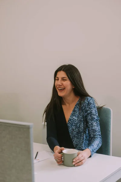 Piękna Brunetka Biznes Kobieta Śmieje Się Siedząc Miejsca Pracy Trzymając — Zdjęcie stockowe
