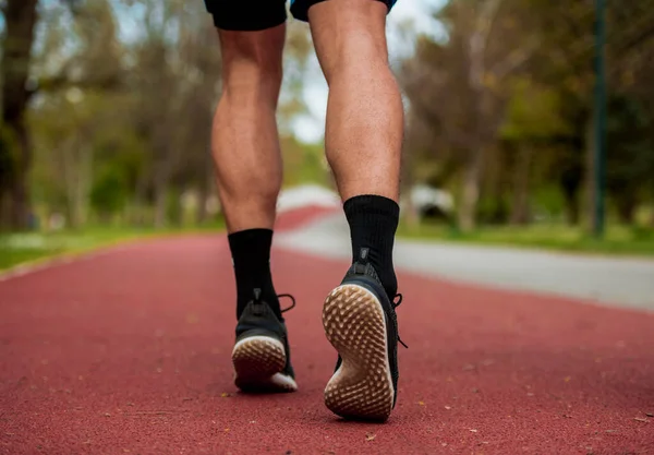 适合跑步的男子慢跑的脚特写跑鞋 夏季马拉松赛时 运动员的腿在红道上行走或慢跑 — 图库照片