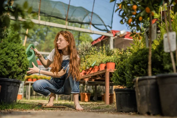 stock image Lovely garden redhead girl digging hole to plant new flower