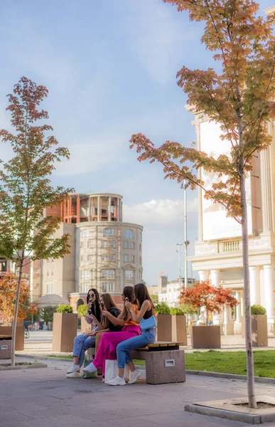 Vier Fantastische Und Lässig Gekleidete Mädchen Sitzen Auf Der Bank — Stockfoto