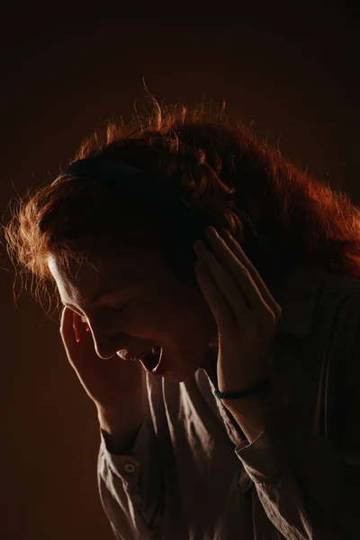 Kulaklığını Takmış Şarkı Söyleyen Bağıran Kızıl Bir Kızın Siluetine Yakın — Stok fotoğraf