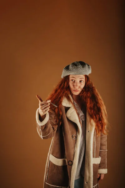 Ginger Κορίτσι Κοιτάζοντας Μακριά Ενώ Κρατώντας Ένα Τσιγάρο Στο Χέρι — Φωτογραφία Αρχείου