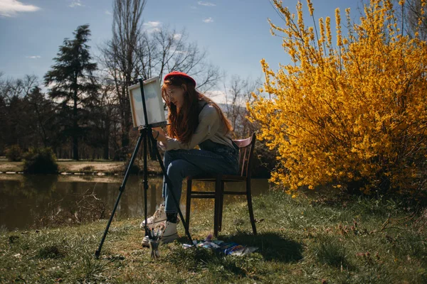 Zázvor Dívka Červeným Baretem Montérky Malování Stojan Zatímco Sedí Dřevěné — Stock fotografie