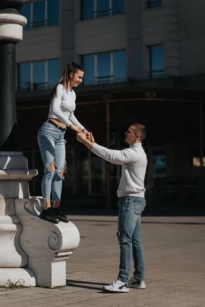 美しい女の子をジャンプしようとしていると彼女のボーイフレンドは彼女をキャッチでザ — ストック写真