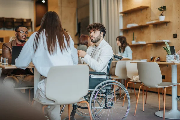 坐在轮椅上的男商人和他在现代办公室的同事一起工作 金融市场 残疾概念 — 图库照片