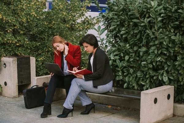 Deux Femmes Affaires Assises Sur Banc Regardant Ordinateur Portable Écrivant — Photo