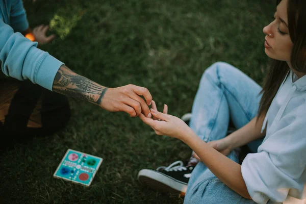 公園に座っている間に女の子にサイコロを与える男の子 — ストック写真