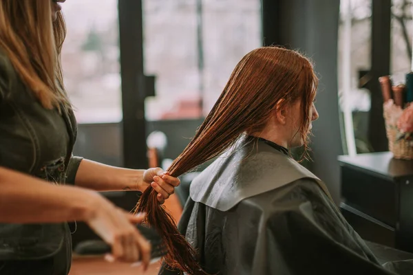 ジンジャークライアントの髪を組み合わせたプロのヘアスタイリスト — ストック写真