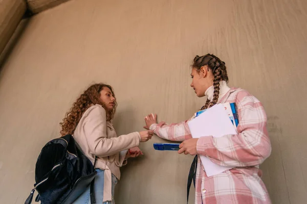 Две Школьницы Разговаривают Брюнетка Вешает Липкую Записку Стену Разговаривая Своей — стоковое фото