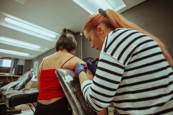 Dövme Sanatçısı Stüdyoda Otururken Esmer Kıza Dövme Yapıyor — Stok fotoğraf