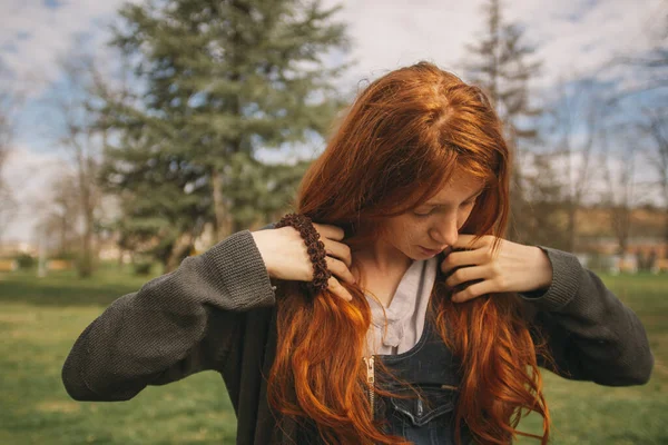 Женщина Огненно Рыжими Волосами Стоит Зеленом Поле Природе Смотрит Вниз — стоковое фото