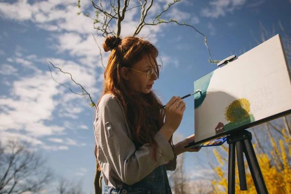Kızıl Uzun Saçlı Bir Kadın Parkta Dururken Sehpada Renkli Bir — Stok fotoğraf