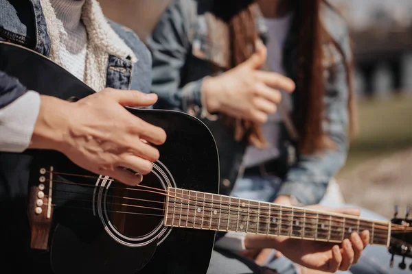 Zbliżenie Człowieka Grającego Gitarze Podczas Siedzenia Swoją Dziewczyną — Zdjęcie stockowe