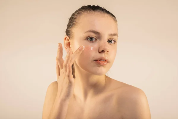 Beautiful Young Girl Applying Aging Face Lotion Isolated — Stock Photo, Image
