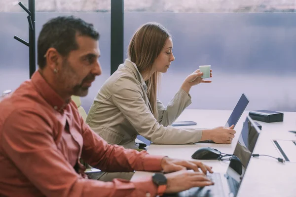 Dwóch Współpracowników Biznesowych Pracujących Swoich Laptopach Siedzących Przy Stole Biznesowym — Zdjęcie stockowe