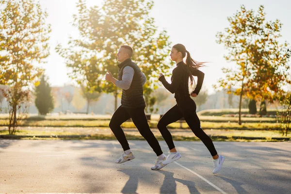 美しい晴れた日に公園で一緒にジョギングする美しいカップルの写真 — ストック写真