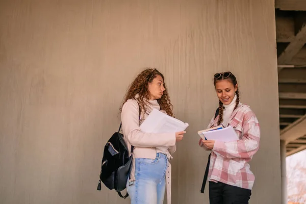 Две Школьницы Читают Книгу Перед Экзаменом Перед Фактурной Стеной — стоковое фото