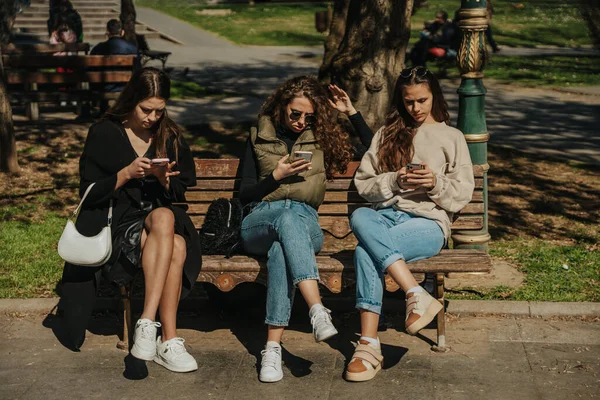 Beautiful Girls Friends Scrolling Social Medias Phones Sitting Bench Park — Stock Photo, Image