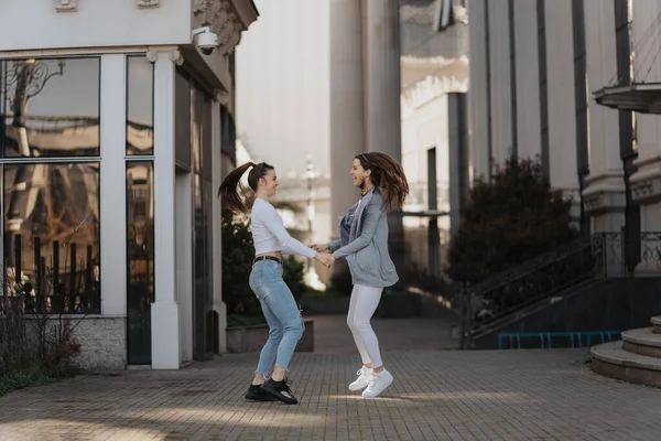 Δύο Νεαρές Γυναίκες Παίζουν Μεταξύ Τους Στο Πεζοδρόμιο — Φωτογραφία Αρχείου