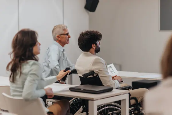 Pracownik Niepełnosprawny Wózku Inwalidzkim Słuchający Wykładów Biznesowych Wraz Swoimi Rówieśnikami — Zdjęcie stockowe