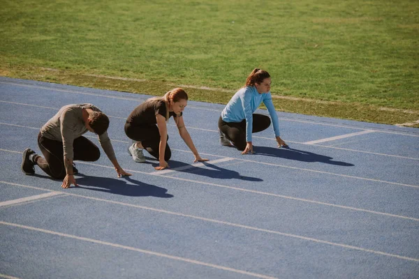 Man Och Två Kvinnliga Idrottare Förbereder Sig För Sprintning — Stockfoto