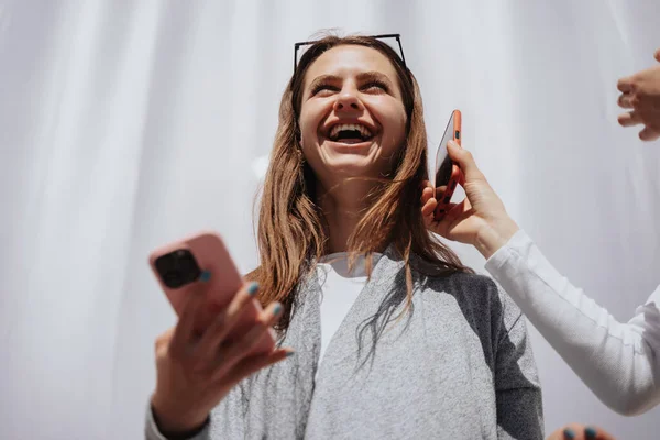 Menina Morena Bonita Sorrindo Enquanto Segura Seu Telefone Rosa Telefone — Fotografia de Stock