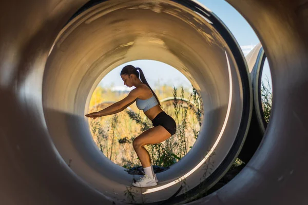 Une Athlète Féminine Fait Des Squats Dans Une Pipe Géante — Photo