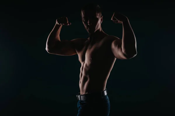 Homem Musculoso Bonito Uma Sala Escura Flexionando Sua Parte Superior — Fotografia de Stock