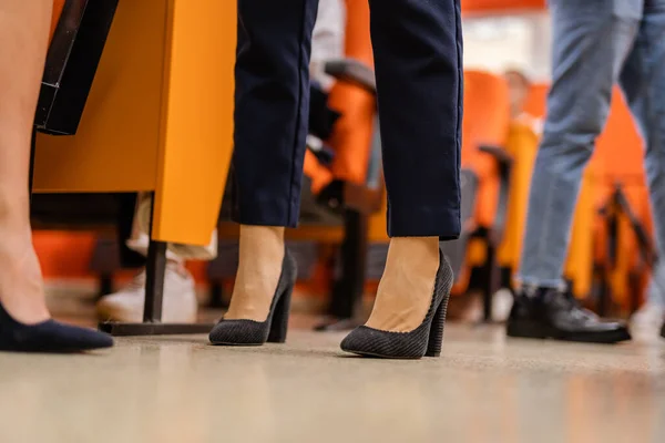Low-angle of a females high heels standing in the class room, faculty meeting, conference hall