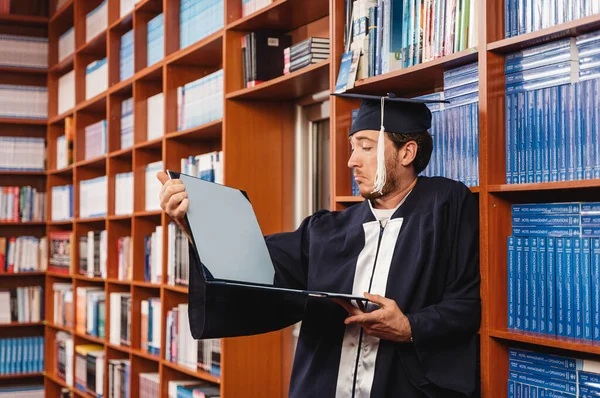 Genç Mutsuz Mezun Üniversite Diplomasına Kütüphanede Bakıyor — Stok fotoğraf