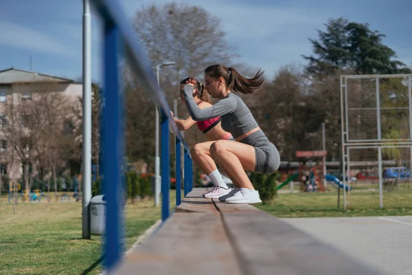 フィットスポーツジョギルスは 晴れた日に公園の屋外でトレーニングしながらベンチでジャンプします — ストック写真