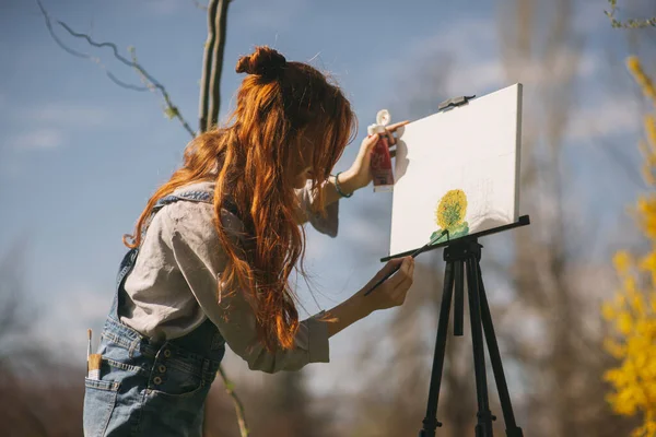 Zbliżenie Imbir Dziewczyna Malowanie Obraz Sztaludze Podczas Stojąc Parku — Zdjęcie stockowe