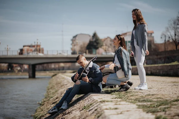 Drei Freunde Spielen Gitarre Und Singen Fluss Der Stadt — Stockfoto