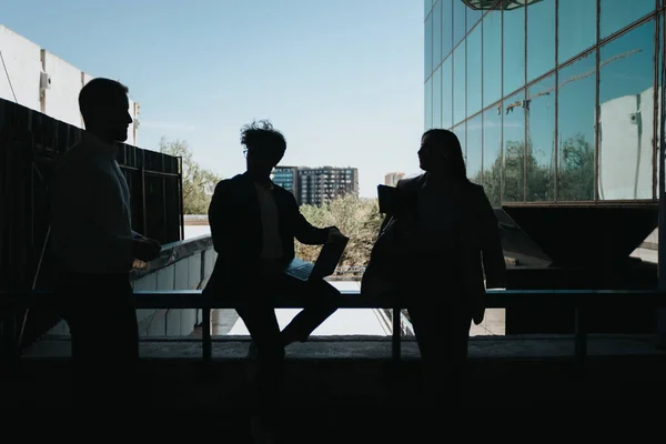 屋外でのミーティングで話し合う3人のビジネスのシルエット — ストック写真