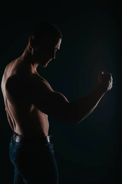 Muskularny Przystojny Mężczyzna Stojący Ciemnym Pokoju Napinający Biceps — Zdjęcie stockowe