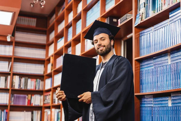 Üniversite Diplomasını Gururla Kütüphanede Saklayan Genç Bir Erkek — Stok fotoğraf