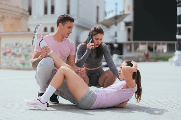 Sportsgirl Machucou Sua Perna Enquanto Fazia Exercício Com Seus Amigos — Fotografia de Stock