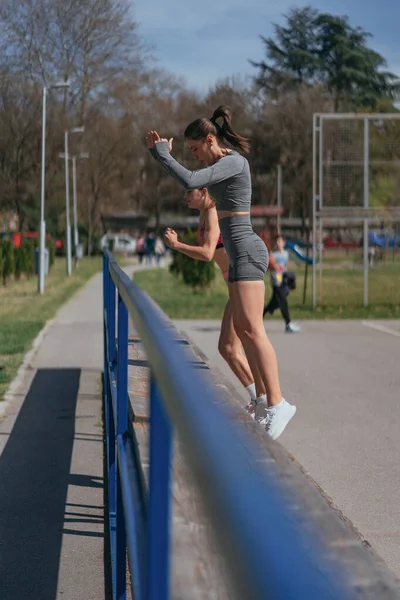 Actieve Sportmeisjes Die Benen Trainen Springt Bank Het Park Zijaanzicht — Stockfoto