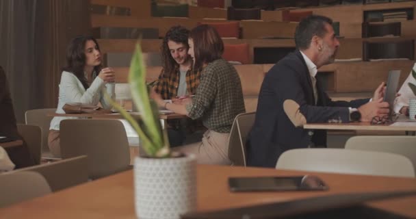 Gruppen Von Geschäftsleuten Die Separaten Tischen Über Die Details Eines — Stockvideo