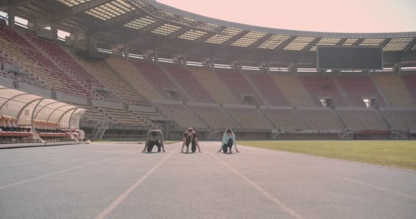 Troje Młodych Ludzi Rywalizuje Torze Biegowym Stadionie — Wideo stockowe