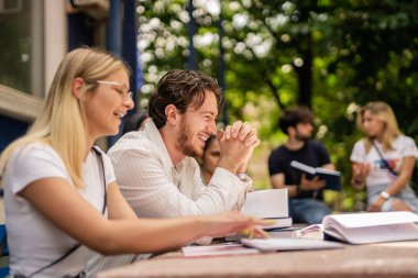 Beautiful students laughing during break, they are having fun conversation clipart