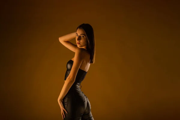 Mädchen Schwarzer Lederkleidung Posieren Vor Beigem Hintergrund Studio Blick Über — Stockfoto