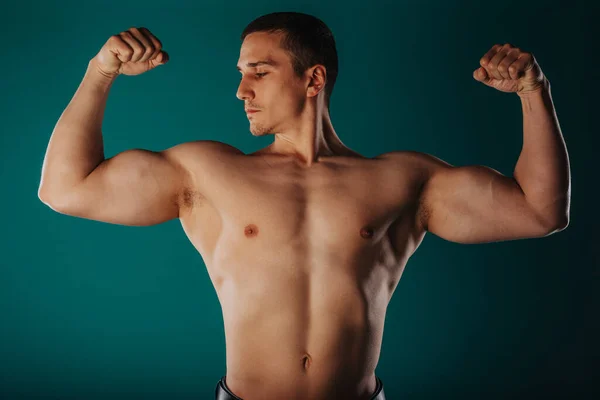 Aesthetic Man Standing Green Room Flexing His Biceps — Stock Photo, Image