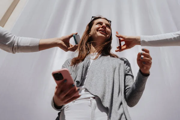Brunette Meisje Houdt Haar Telefoon Vast Terwijl Wegkijkt Haar Vrienden — Stockfoto