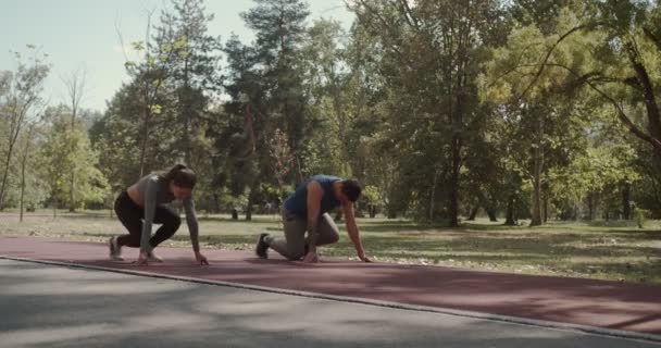 秋の公園のレースコースで走り始めるカップル — ストック動画