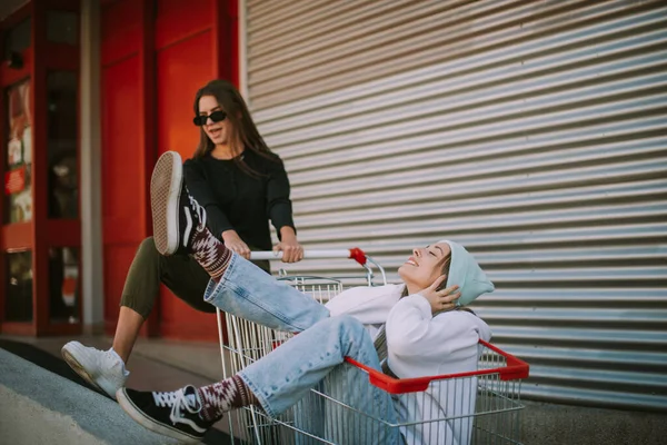 Nahaufnahme Von Zwei Hübschen Mädchen Die Spaß Mit Einem Marktwagen — Stockfoto