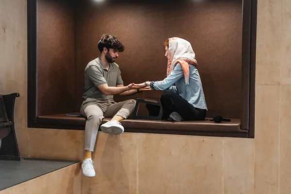 Muž Žena Dotýkají Ruce Zatímco Sedí Zapuštěném Prostoru Zdi — Stock fotografie