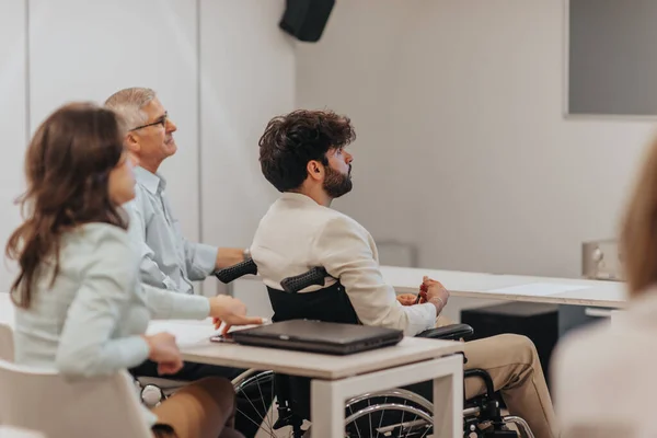 Engelli Konsepti Sınıftaki Farklı Yaştaki Meslektaşlarıyla Konferansı Dinleyen Engelli Erkek — Stok fotoğraf