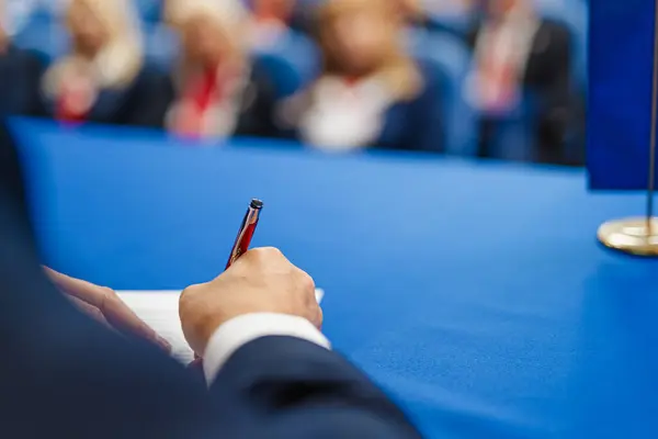 Close Shot Mans Hand Writing Sheet Paper Conference Hall — Stock Photo, Image