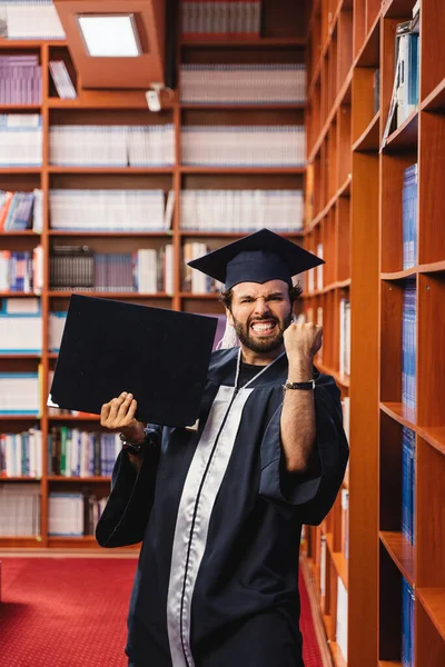 Young Excited Graduate Wearing Cap Gown While Holding His Bachelor — Stock Photo, Image